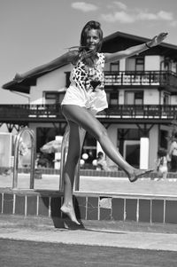 Excited woman jumping in joy at poolside