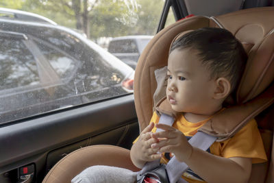 Close-up of little boy children on a car seat in the car.