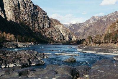 Scenic view of lake by mountains against sky