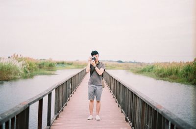 Woman standing on lake against sky