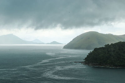 Scenic view of sea and mountains against sky