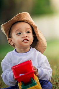 Portrait of young woman wearing hat standing outdoors