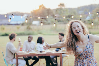 Joyful blonde enchants sunny garden bbq with laughter