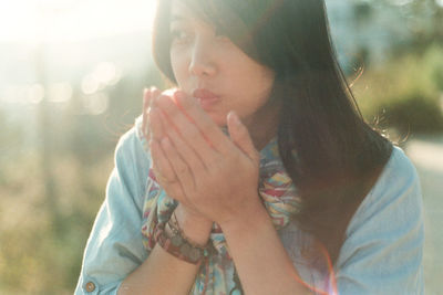 Close-up of woman blowing on hands