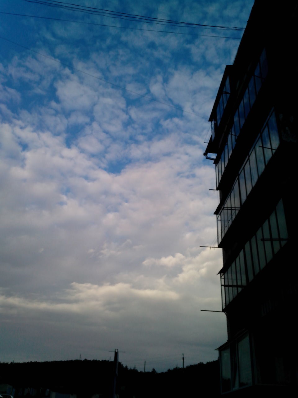 low angle view, architecture, sky, built structure, building exterior, cloud - sky, silhouette, cloud, cloudy, building, outdoors, no people, city, dusk, nature, day, power line, sunset, sunlight, residential building