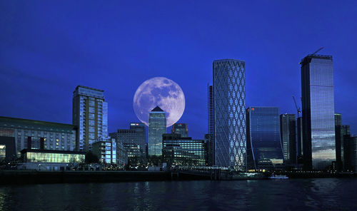 Modern buildings in city with full moon