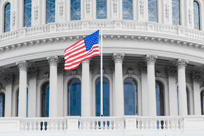 Low angle view of flag against sky in city