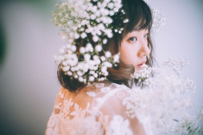 Close-up portrait of young woman with flowers