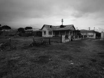 Abandoned house on field against sky