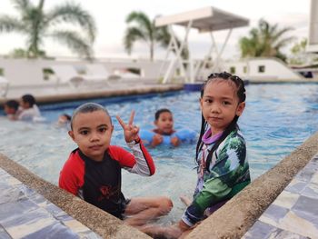 Portrait of cute kids playing in swimming pool