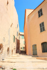 Street amidst buildings against blue sky