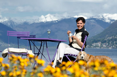 Portrait of happy woman with dog at outdoor cafe