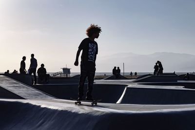 People on skateboard in park against sky