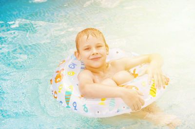 High angle portrait of smiling boy in swimming pool