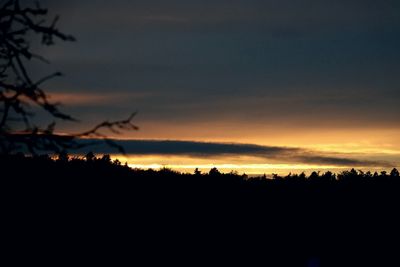 Silhouette landscape against dramatic sky during sunset