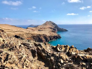 Scenic view of rocks in sea against sky