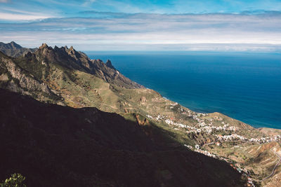 Scenic view of sea and mountains against sky