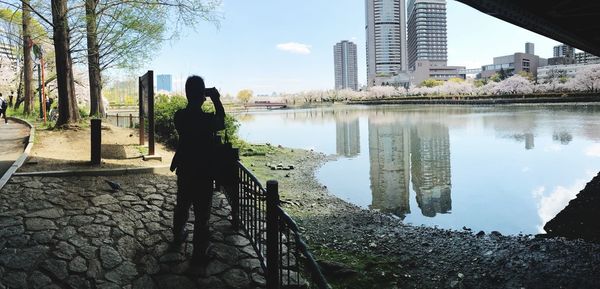 Man standing by railing in city