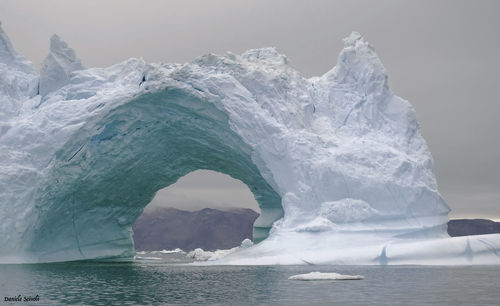 Iceberg in sea against sky