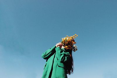 Low angle view of flowering plant against blue sky