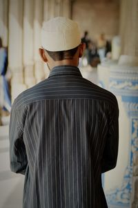 Rear view of man standing on cross