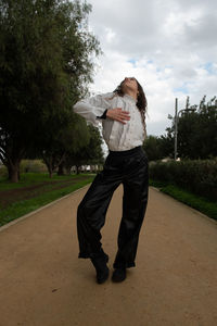 Rear view of woman standing against trees