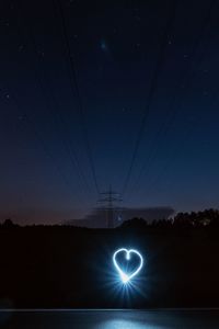 Illuminated lights against sky at night