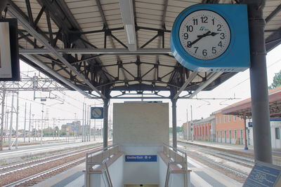 Piacenza, italy -  a big blue clock over the binary near the exit in train station