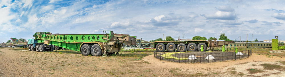 Abandoned train on field against sky