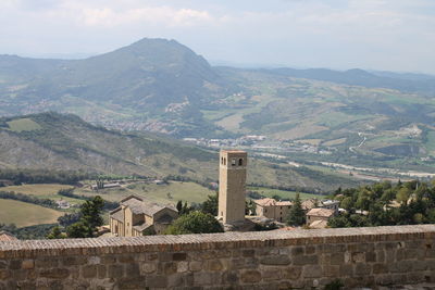 Scenic view of town by mountains against sky