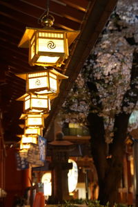 Low angle view of illuminated lanterns hanging by building