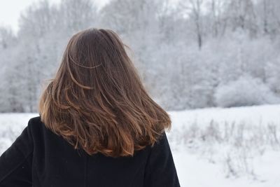 Rear view of woman standing in snow