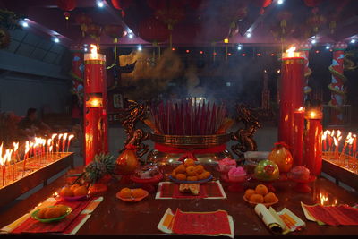 Illuminated candles in temple at night