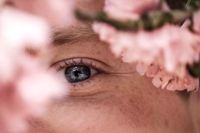 Cropped portrait of man by pink flowers