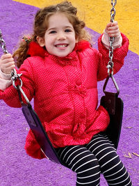 Portrait of boy swinging at playground