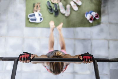 Overhead view of man hanging on gymnastics bar at health club