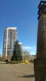 Buildings in city against clear blue sky