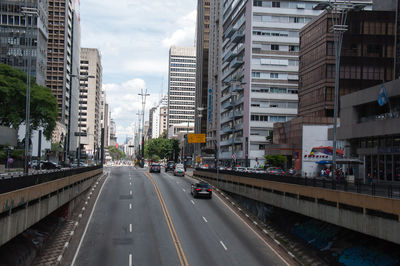 Traffic on road amidst buildings in city