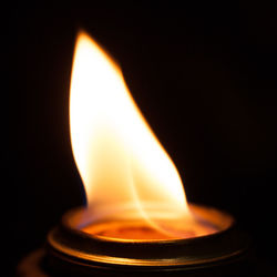 Close-up of illuminated candle against black background