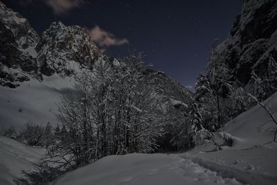 Scenic view of snow covered mountains against sky at night