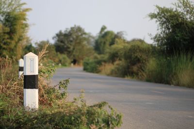 Close-up of kilometer pole by road.