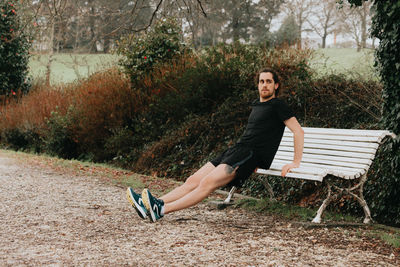 Full length of man exercising by bench