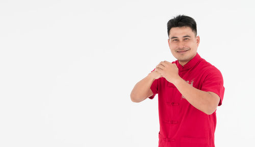 Portrait of young man standing against white background