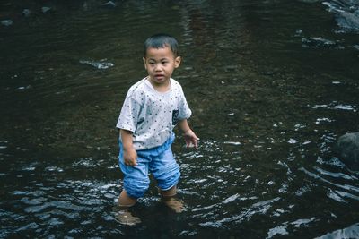 High angle view of cute girl standing in water