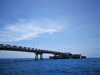 View of bridge over sea against blue sky