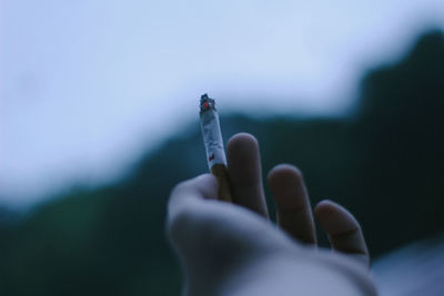 Close-up of hand holding cigarette