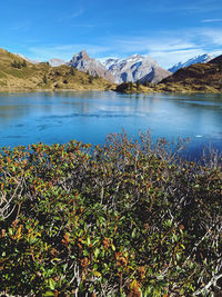 Scenic view of lake by mountains against sky