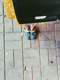 Low section of woman standing on footpath