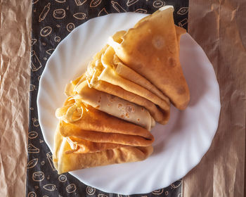 Pancakes rolled into triangles lie on a white trawl on a paper napkin close-up top view