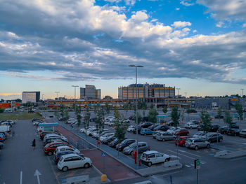 Traffic on road by buildings in city against sky